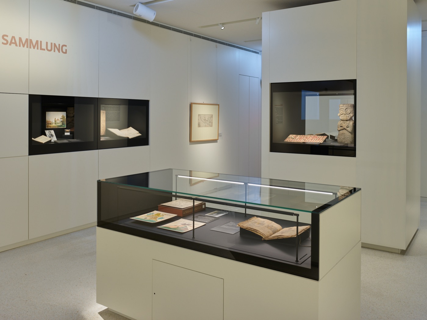 Wechselausstellungsbereich im Stabi-Kulturwerk, helle Wände und Ausstellungsmöbel mit schwarzen Innenflächen und integrierter Beleuchtung, Tischvitrinen und Wandvitrinen